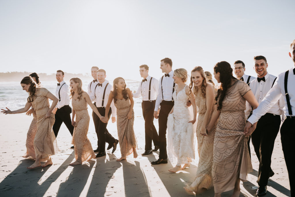 Bridal Party walking on sandy beach in Pebble Beach