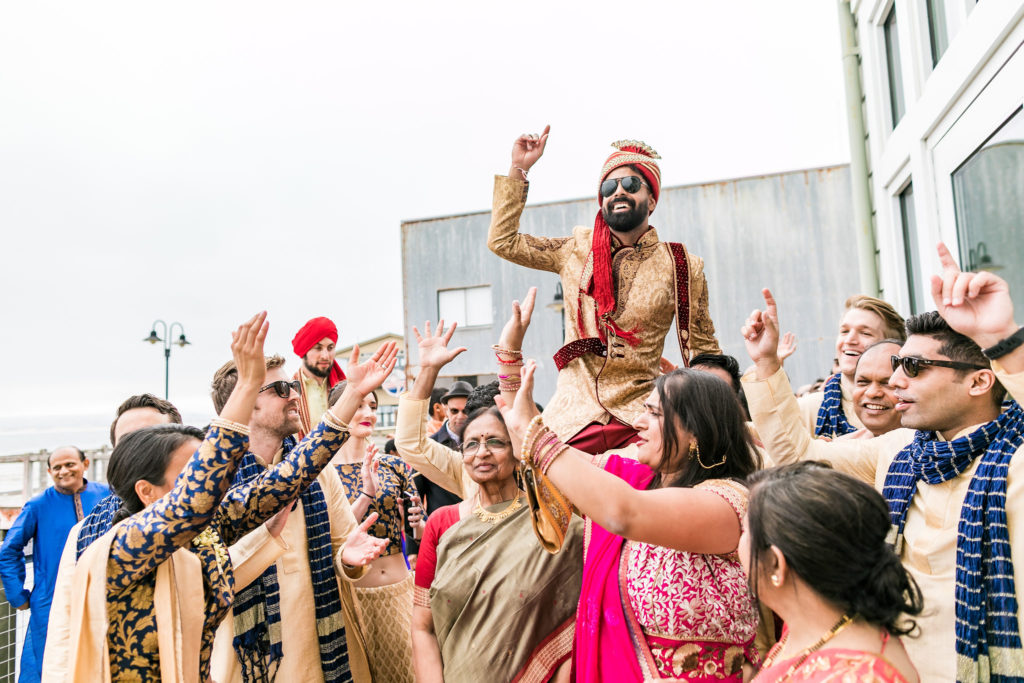 Indian groom being carried in the baraat to the indian wedding ceremony in Monterey