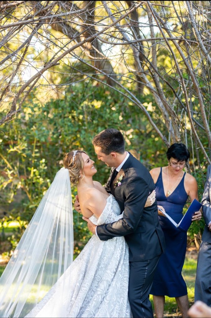 Couple embracing for their first kiss at wedding ceremony