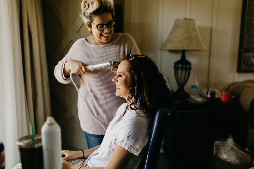 Bride getting her hair curled on wedding day in Carmel