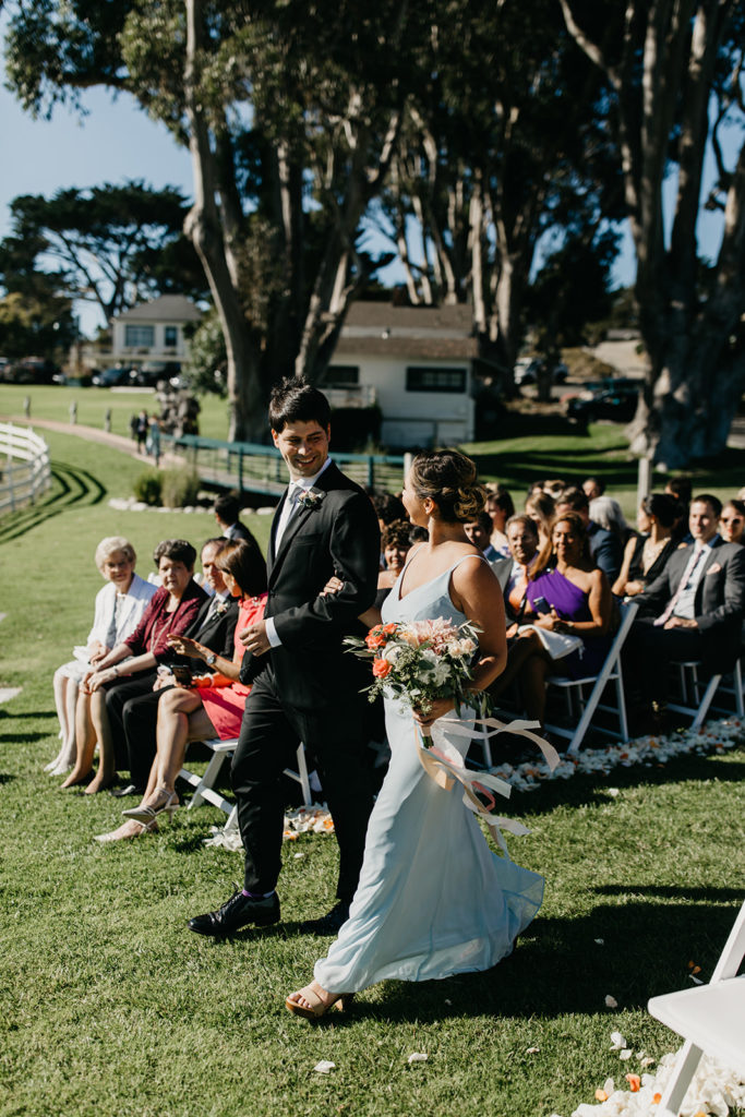 bridesmaid and groomsman walking down the aisle at Mission Ranch in Carmel