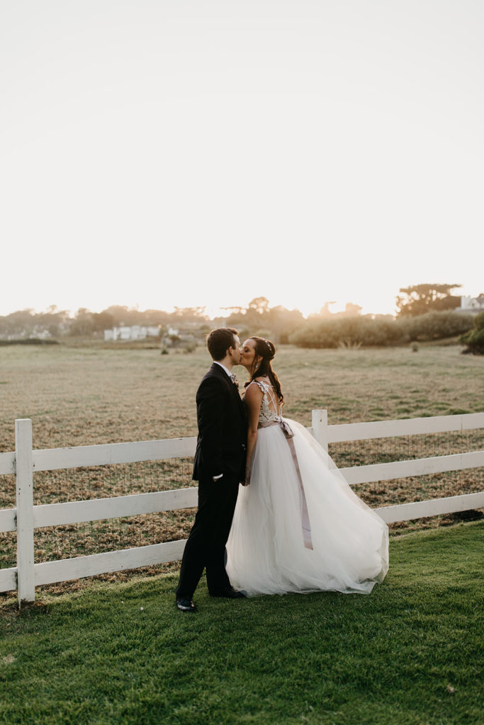 Couple kissing at Sunset in Carmel at Mission Ranch