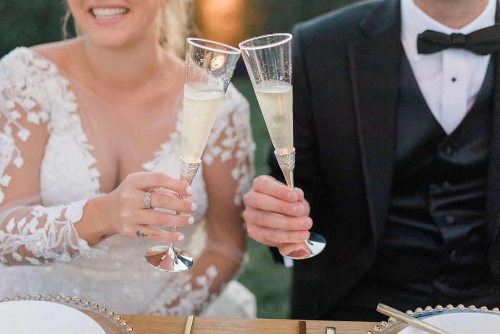 Bride and Groom cheering champagne flutes at dinner.